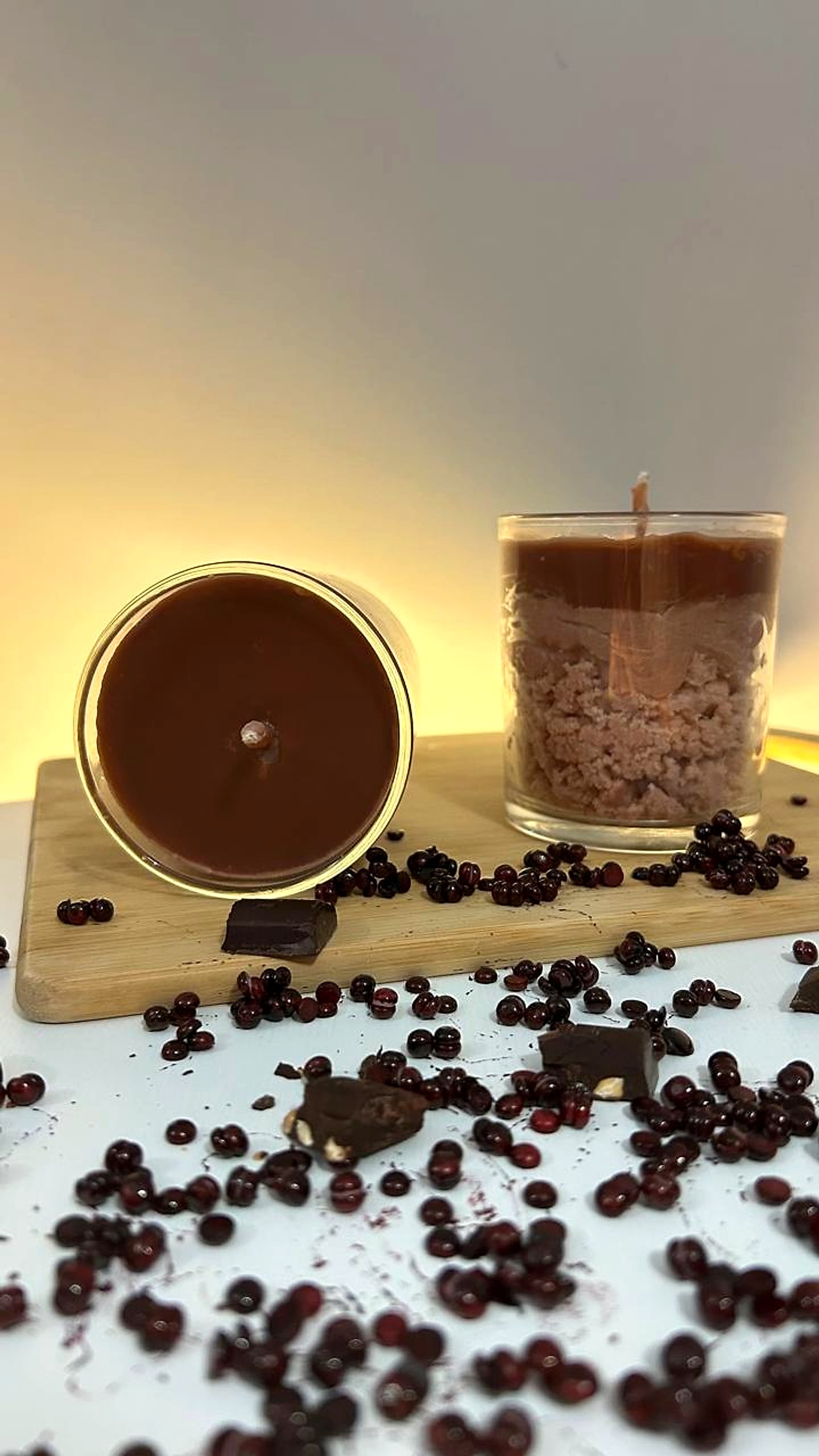 Chocolate soy candles styled with pomegranate seeds and dark chocolate